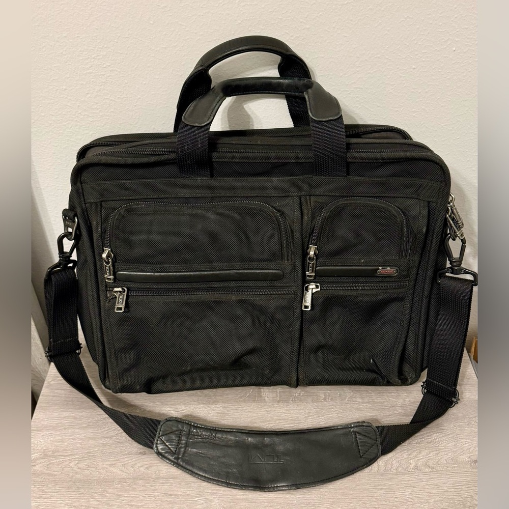 TUMI black laptop carrier bag. It has wallet inside.  It has various